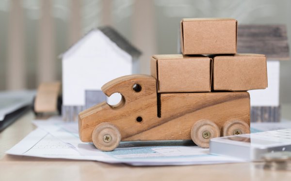 Small wooden truck loaded with carton boxes for moving. Closeup