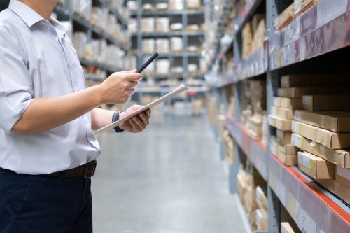 Wholesale, logistic, business, export and people concept - Man warehouse worker with clipboard checking goods at warehouse.