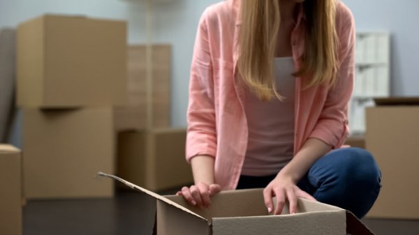 Girl unboxing stuff in new apartment, buying property, start of independent life