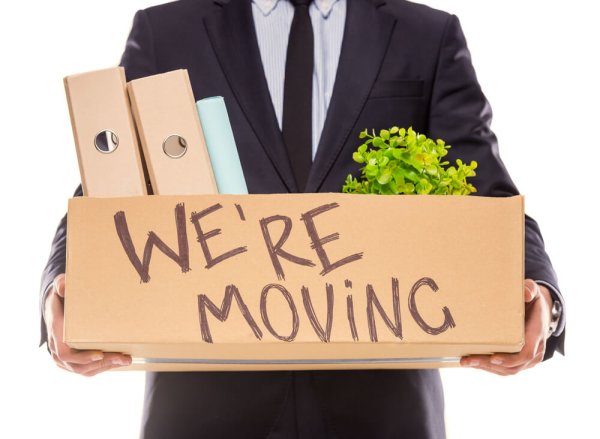 Young happy businessman with box for moving into a new office. Studio shot, isolated on a white background